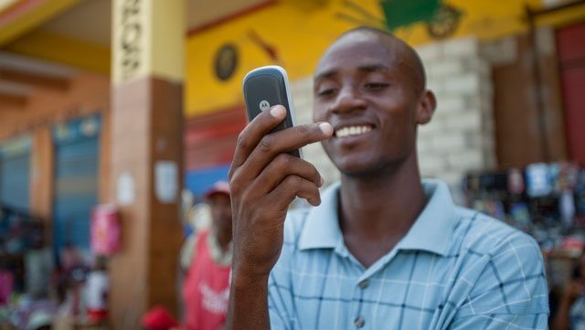 Jean Louis Thomas of Haiti writes a text message to a friend. Many people living on less than $2/day already have access to a mobile phone. (Image courtesy of the Gates Foundation)